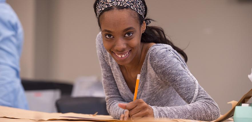 Smiling student sketching